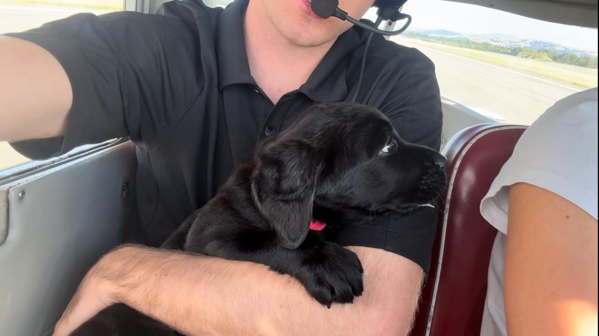 GP Flyers pilots in the cockpit with a Canine Companions puppy